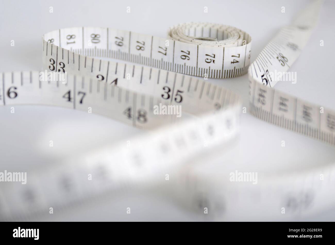 Maßband, zur Messung des Körpers.konzeptionelle Bilder zur Messung von Produktivität, Wachstum, Gewichtszunahme, Ernährung, gesundes Leben und andere Stockfoto