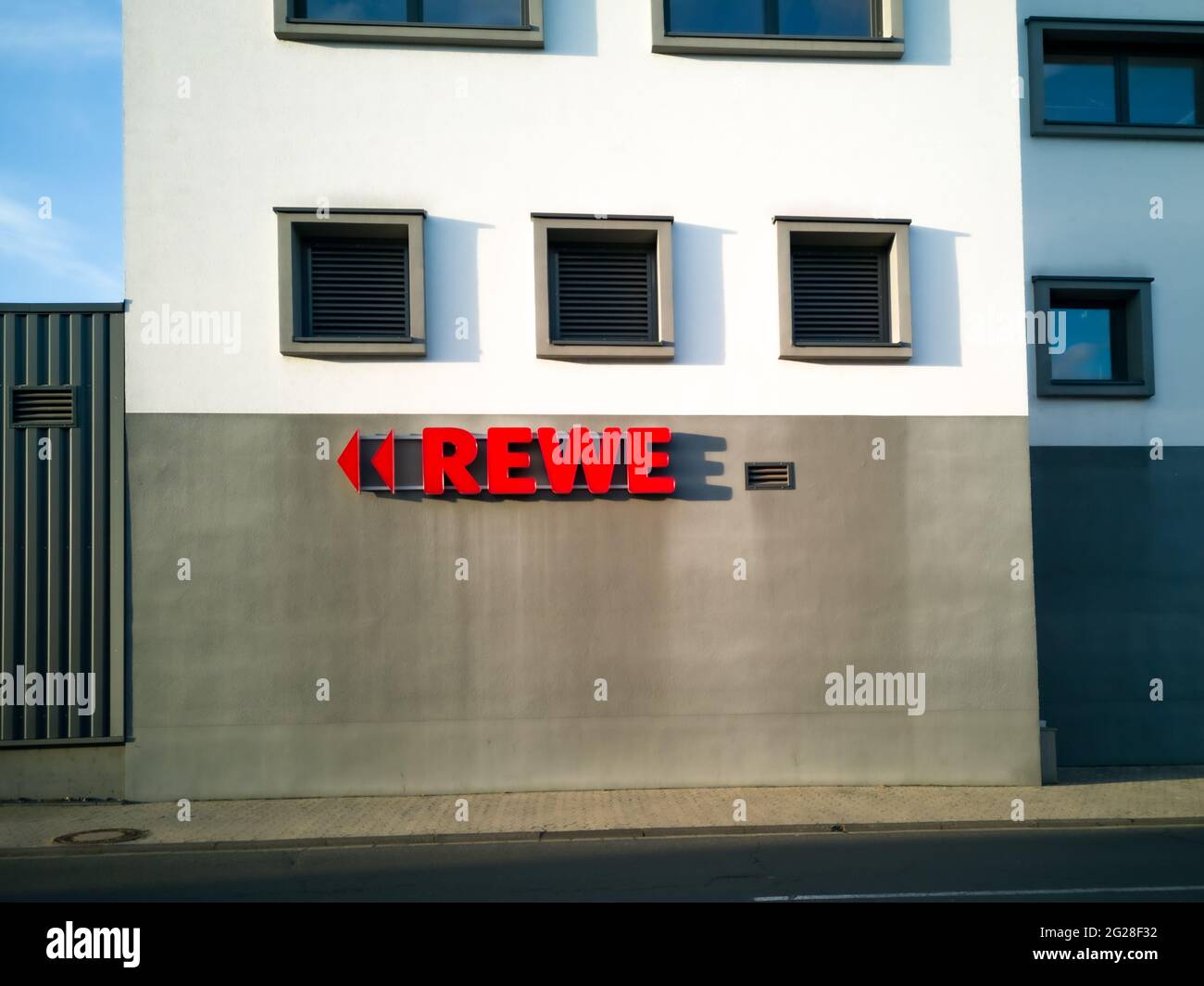 NEUWIED, DEUTSCHLAND - 12. Nov 2020: Neuwied, Deutschland - 12. November 2020: Rotes REWE Label mit Dreiecken als Richtungszeichen außen an einer Wand - copy Spa Stockfoto