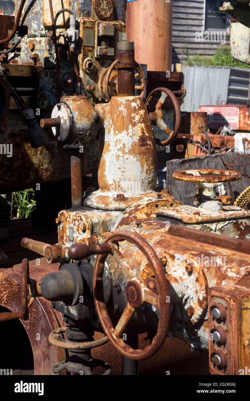 Veraltete Industriemaschinen, die in einem Schrottplatz im Land sitzen und rosten, warten darauf, verschrottet zu werden. Stockfoto