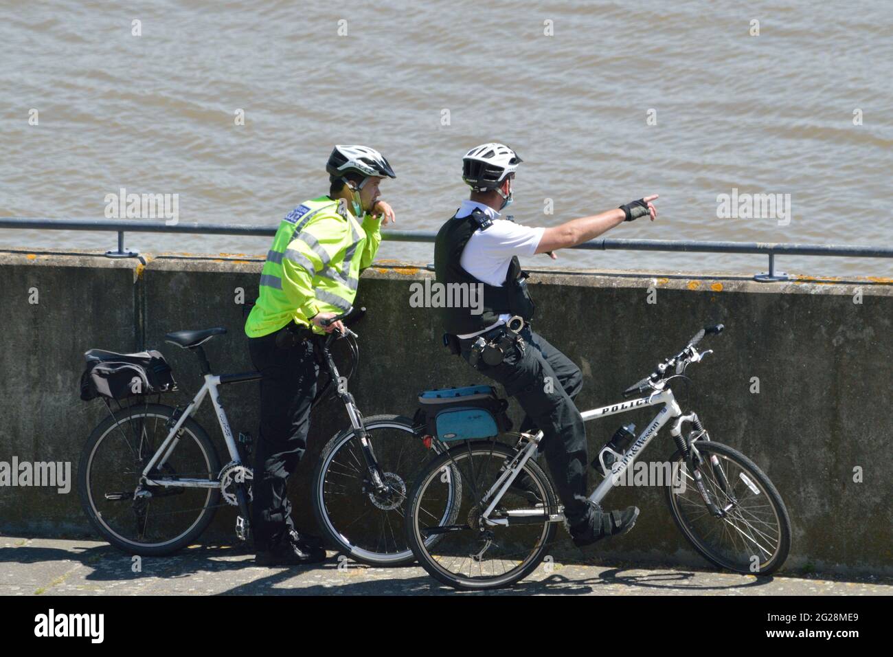 Zwei Polizisten aus Newham MPS auf einer Fahrradpatrouille, die Gallions Point im Londoner Royal Docks-Viertel besucht Stockfoto