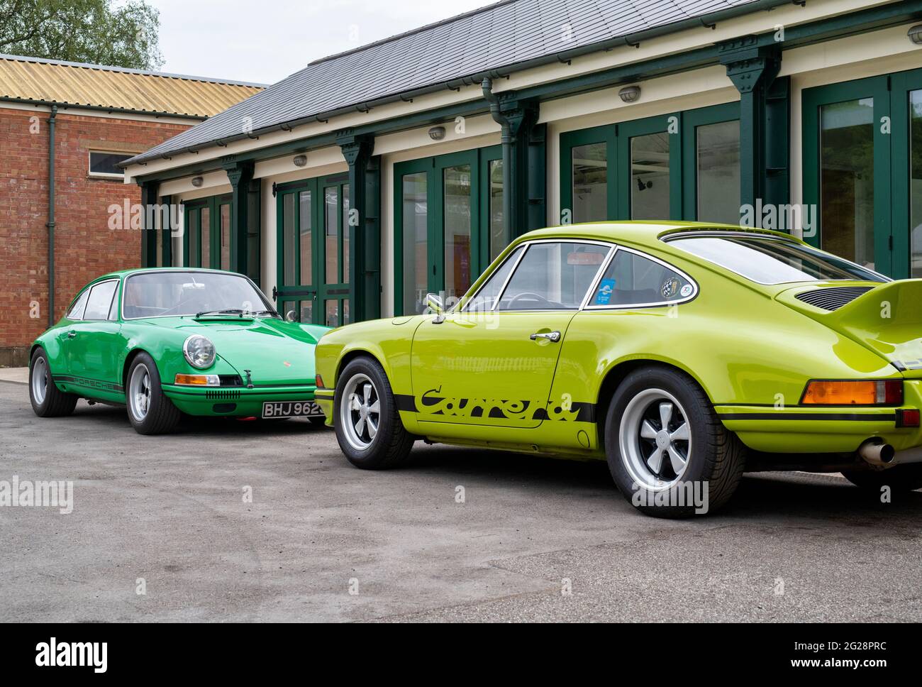 Porsche Autos vor einer Garage im Bicester Heritage Center. Bicester, Oxfordshire, England Stockfoto