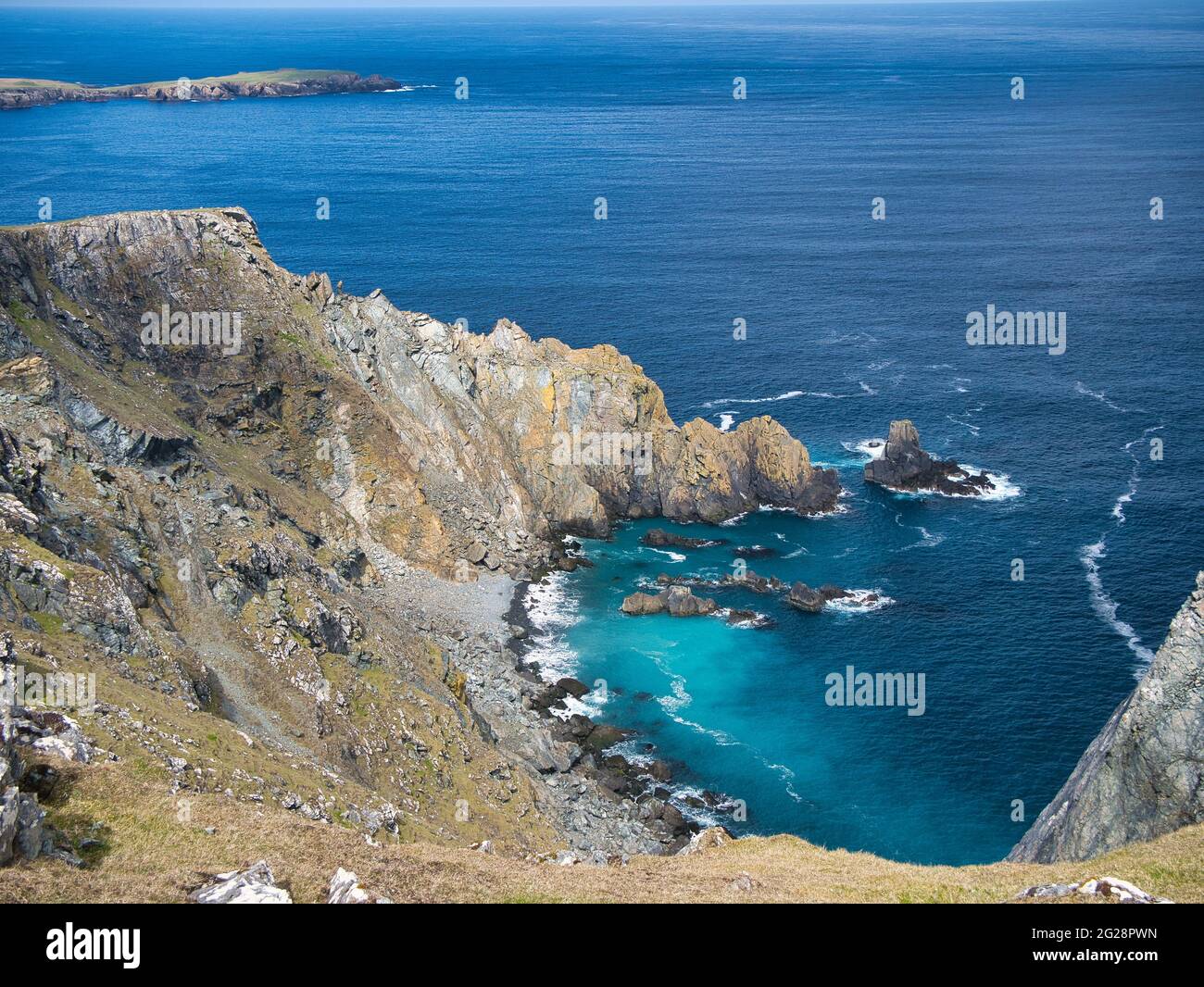 Meeresklippen und türkisfarbenes Wasser rund um Clibberswick auf der Insel Unst in Shetland, Großbritannien - diese Felsen sind Teil des geologisch bedeutsamen Shetla Stockfoto