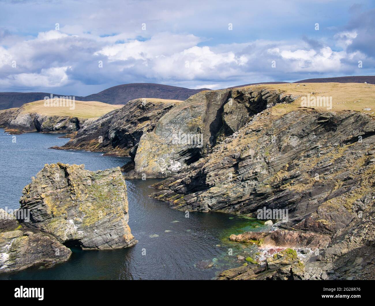 Geneigte Schichten im Küstengestein bei Kenna Ness, Shetland, Großbritannien. Ein unbenannter unverschämter Einbruch, späte silurische bis frühe Devon-Periode Stockfoto