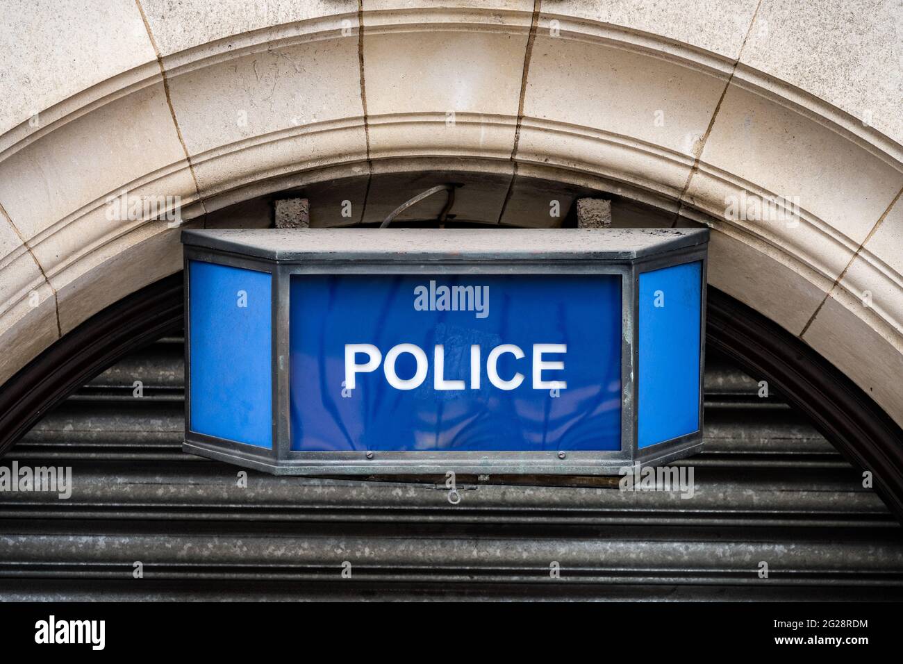 Traditionelles altmodisches blaues Polizeischild im Retro-Stil über der Stadtbahnhoftür aus gewölbtem Stein. Britische Polizei ikonischen blauen Lampe weißen Text angebracht Stockfoto