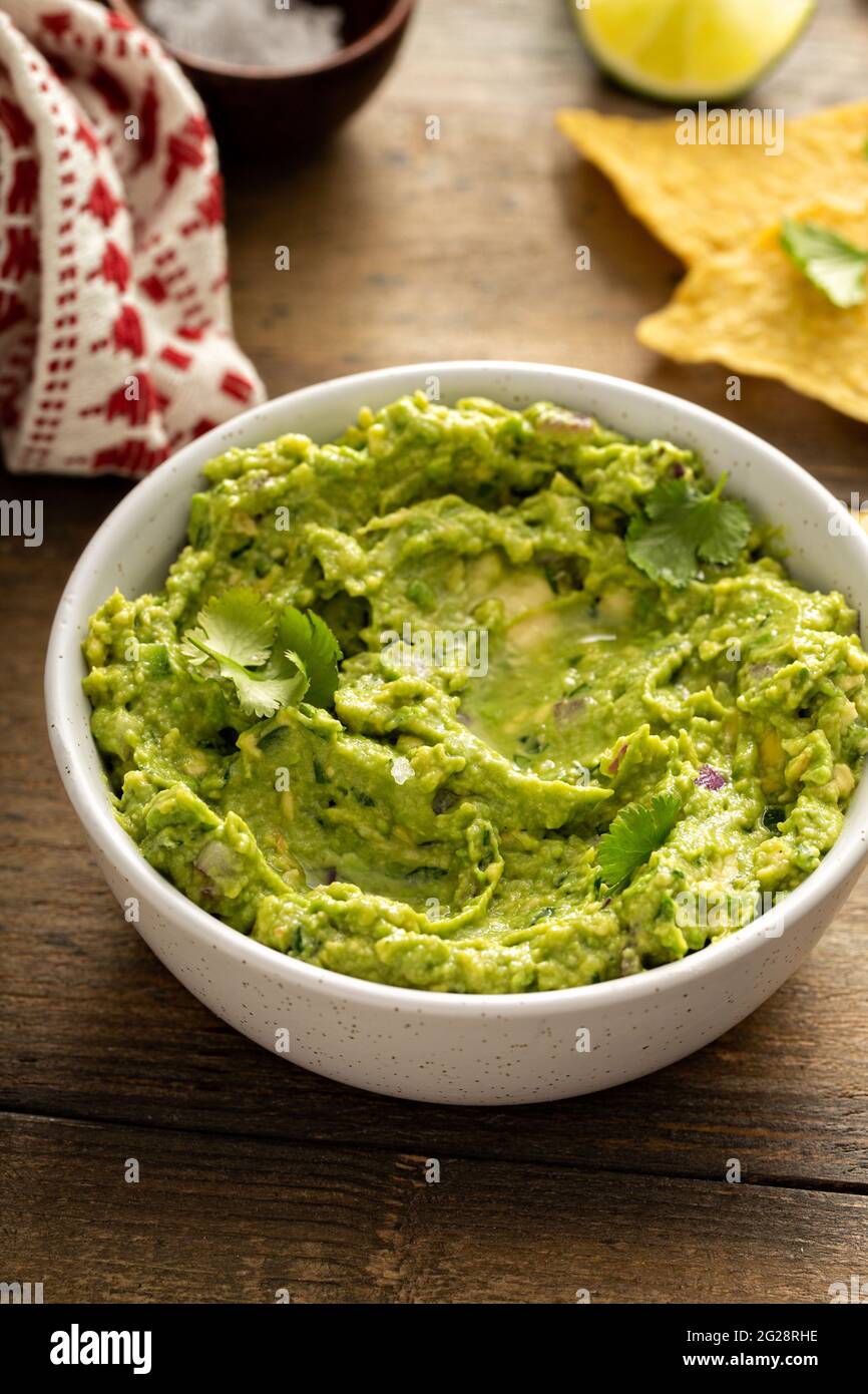 Grob hausgemachte Guacamole in einer Schüssel mit Tortilla-Chips Stockfoto