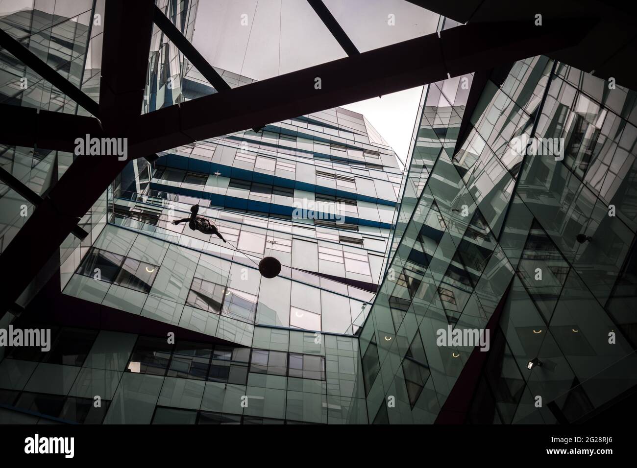 Birmingham, The Cube futuristisches Gebäude, offenes Dach mit einem Mann, der einen Ballon am Himmel hält, und Vögeln, die über Glasfenstern fliegen, einem Sturm des modernen Designs Stockfoto