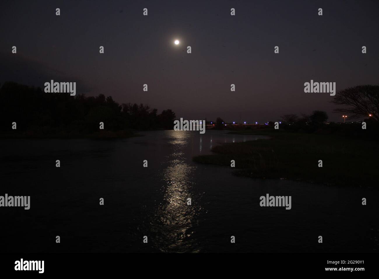 Verträumte Fotografie des Mondes, der sich in Lake at Night in Vrindavan Gardens, Mysore, Indien, spiegelt Stockfoto
