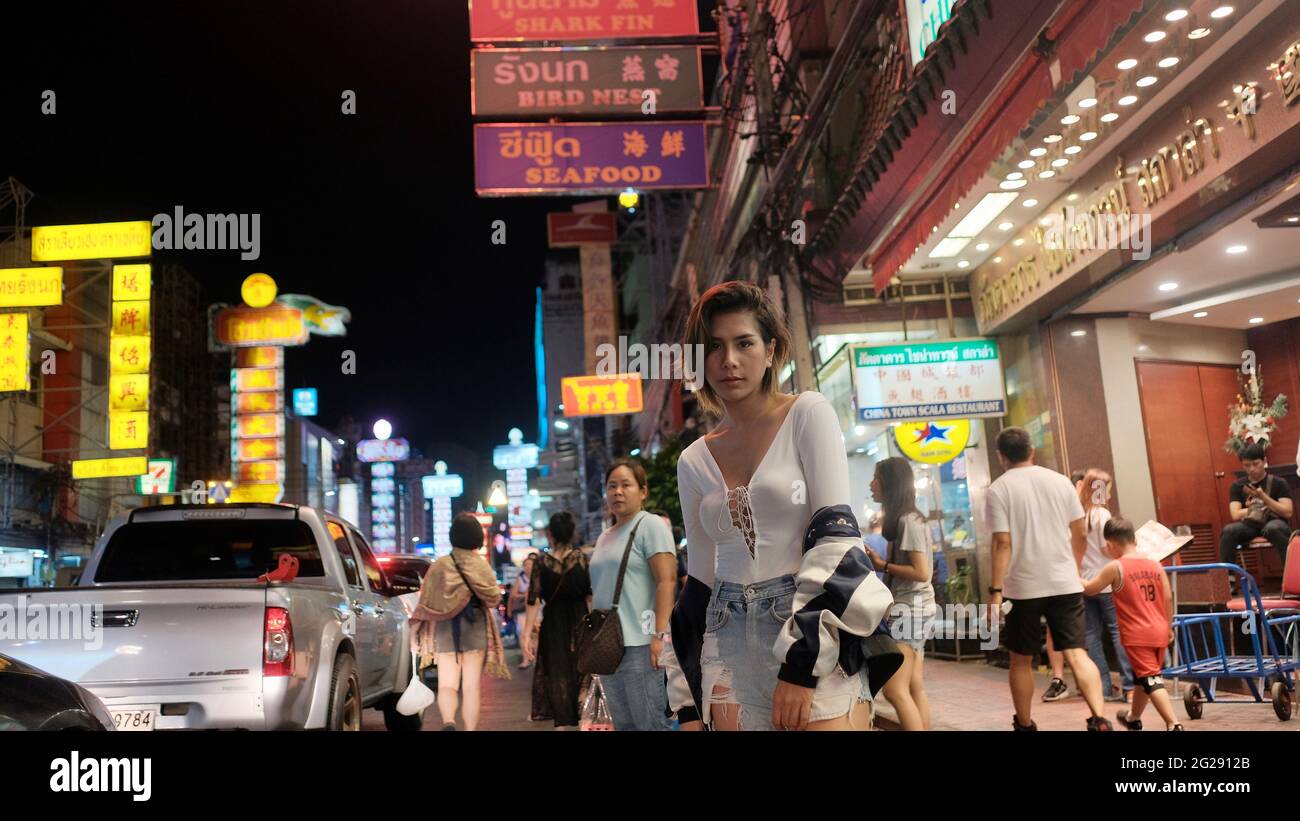 Super Model trägt eine Whit Bluse mit Menschen im Hintergrund auf Yaowarat Road Chinatown Bangkok Thailand Stockfoto