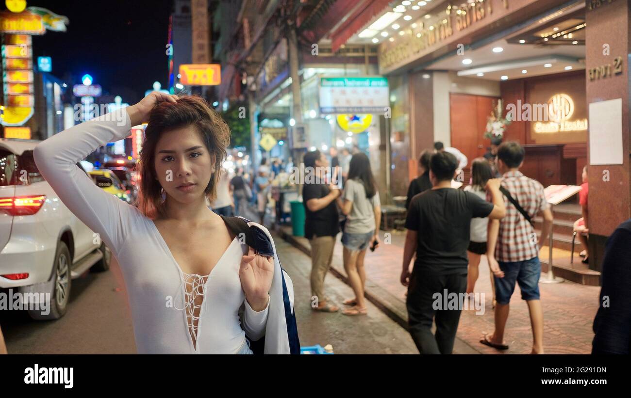 Super Model trägt eine Whit Bluse mit Menschen im Hintergrund auf Yaowarat Road Chinatown Bangkok Thailand Stockfoto