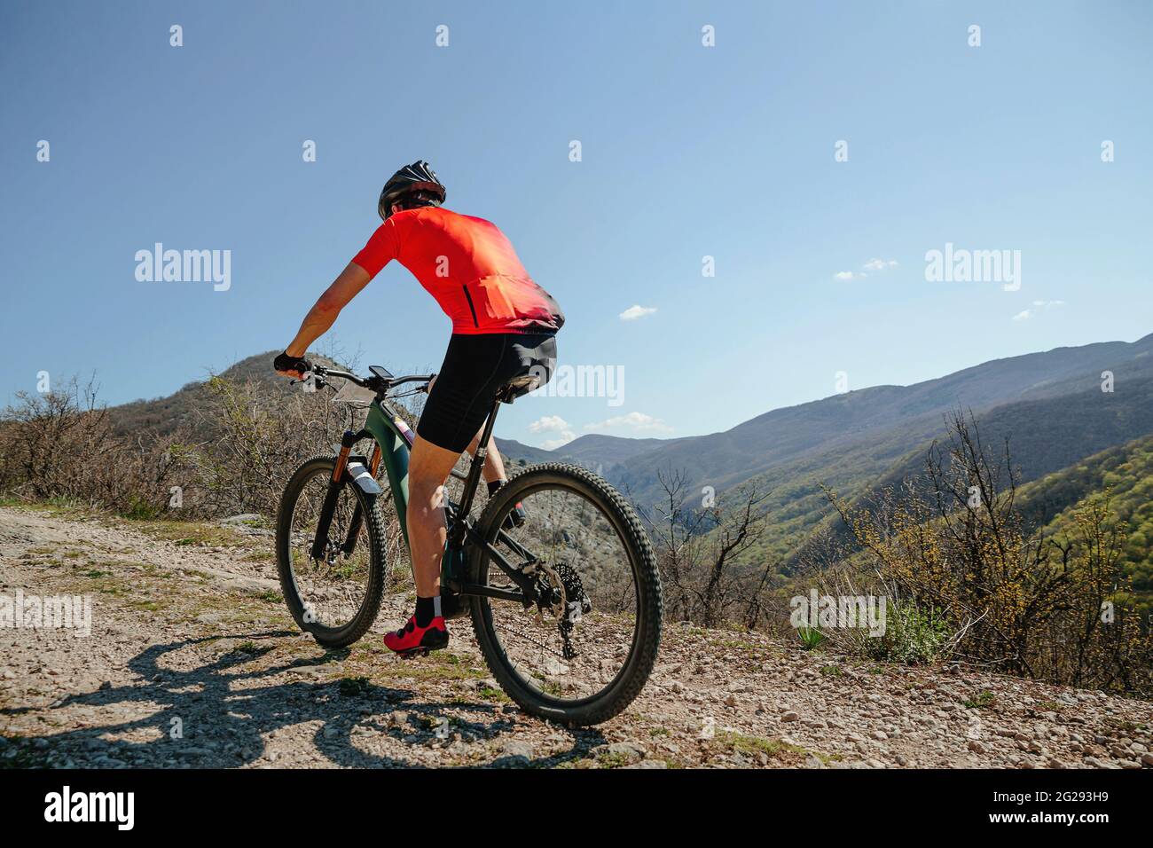 Mann auf Fahrrad Reiten Bergweg im Hintergrund blauen Himmel und Berge Stockfoto