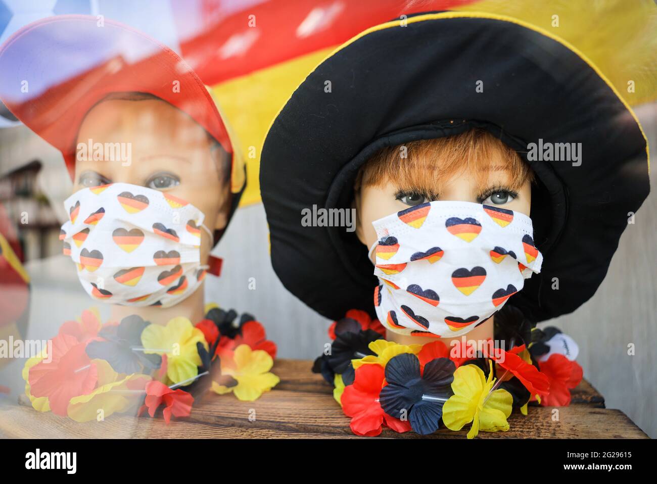 Herzogenaurach, Deutschland. Juni 2021. Schaufensterpuppen mit Mund-Nase-Protektoren und andere Dekorationen in Deutschlands Farben sind im Fenster einer Apotheke zu sehen. Die deutsche Fußballnationalmannschaft und die Support-Mitarbeiter bleiben für die Dauer der Europameisterschaft auf dem Heimgelände des DFB-Partners Adidas. Quelle: Christian Charisius/dpa/Alamy Live News Stockfoto