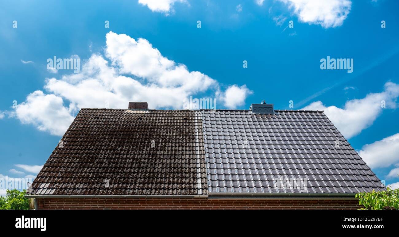 Eine Hälfte gereinigt Haus Dach zeigt die vor und nach dem Effekt eines Dach Reinigung. Stockfoto