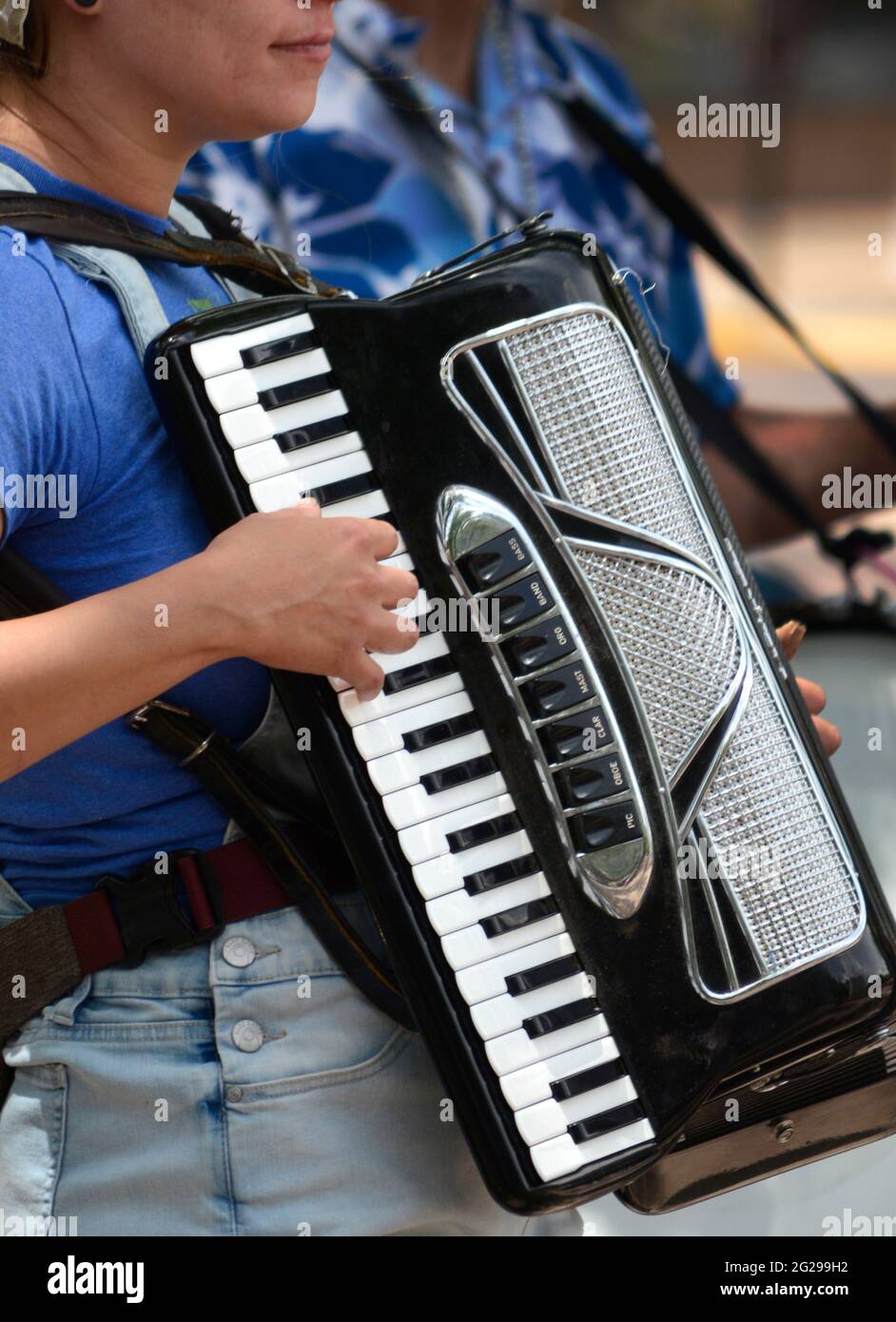 Eine junge Frau spielt in Santa Fe, New Mexico, eine Ziehharmonika für Trinkgelder. Stockfoto