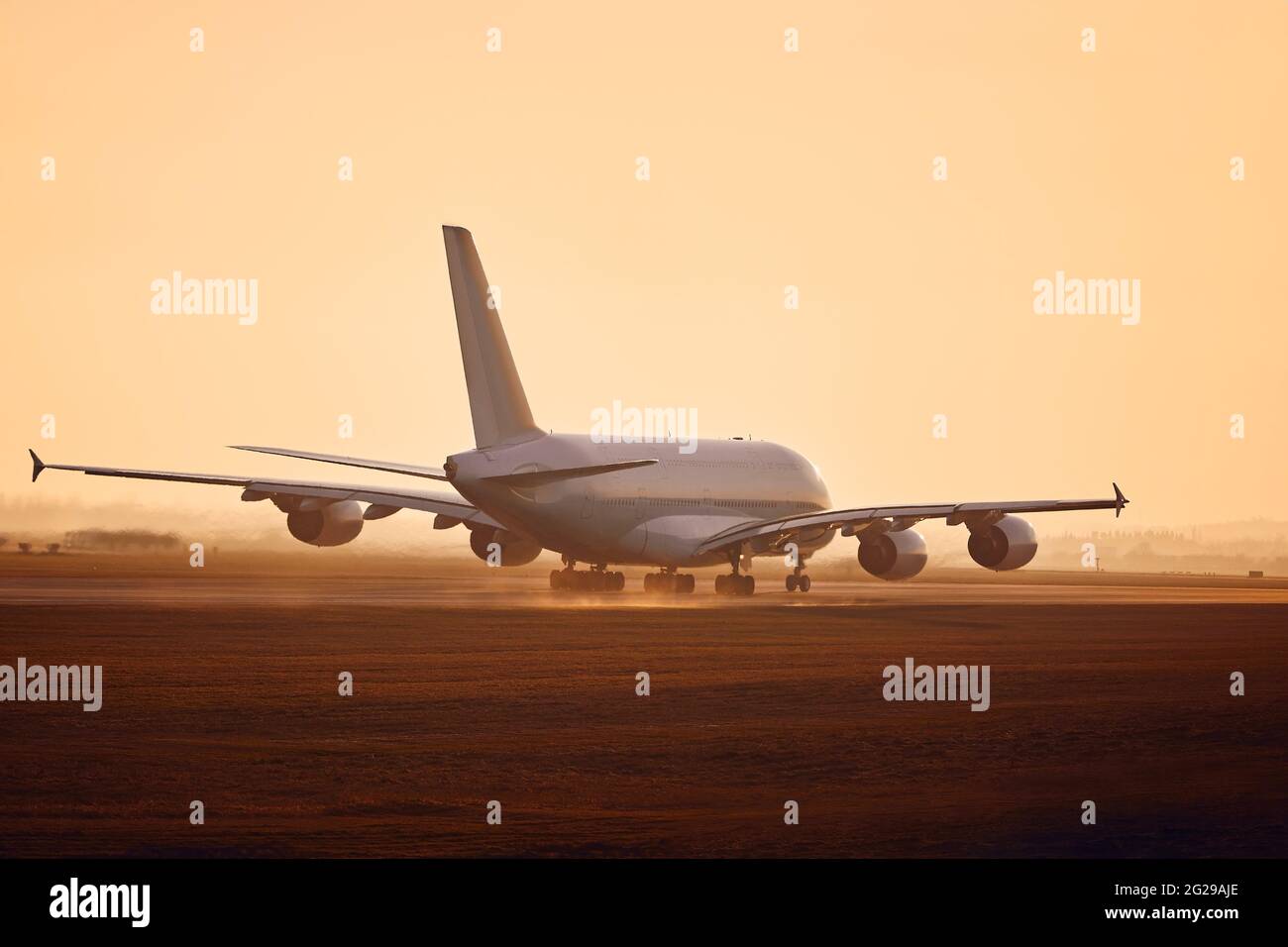 Riesiges Flugzeug, das bei goldenem Sonnenuntergang von der Start- und Landebahn des Flughafens abfliegt. Stockfoto