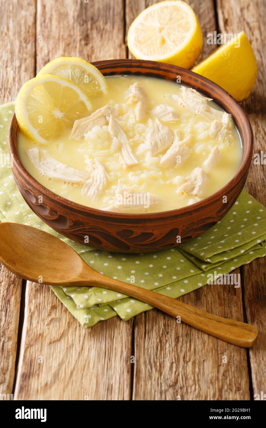 Kotosoupa ist eine leckere und herzhafte griechische Hühnersuppe aus der Nähe auf dem Teller auf dem Tisch. Vertikal Stockfoto