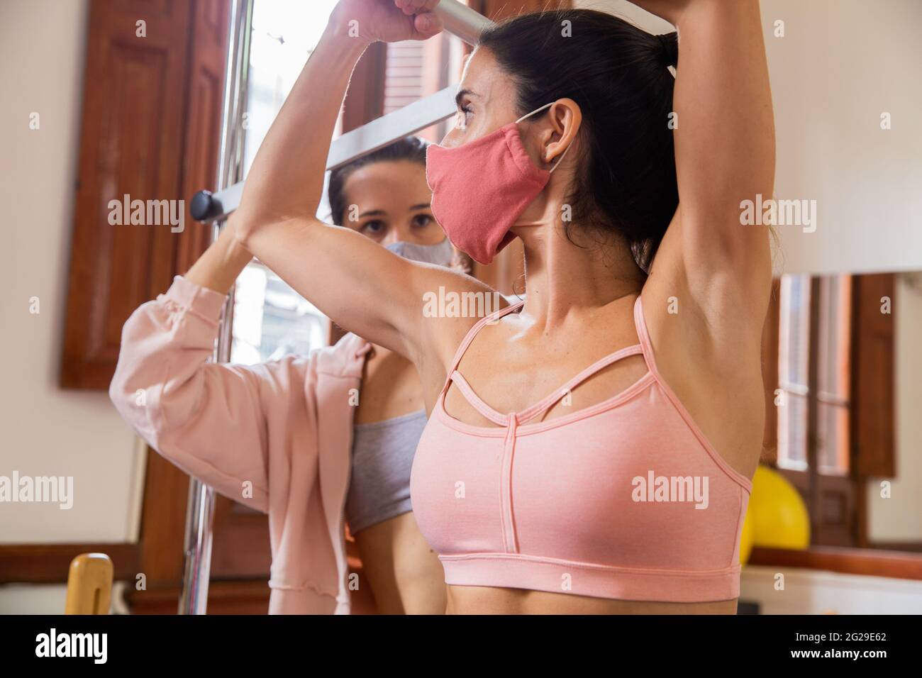 Zwei Frauen trainieren Pilates mit Gesichtsmaske in einem neuen normalen Lebenskonzept Stockfoto
