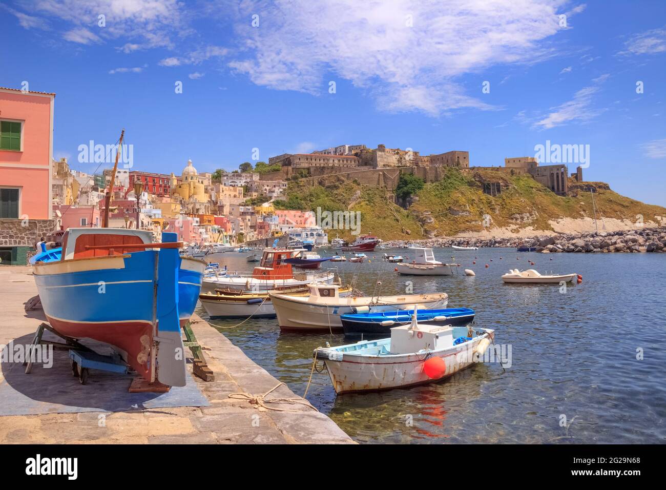 Panoramablick auf Procida, italienische Kulturhauptstadt 2022: Bunte Häuser, Cafés und Restaurants, Fischerboote und Yachten in Marina Corricella. Stockfoto