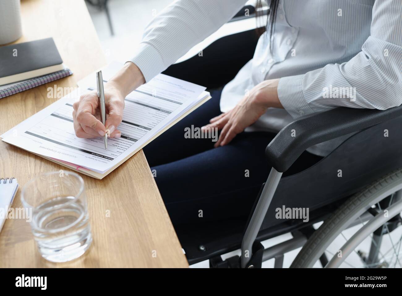 Behinderte Frau im Rollstuhl Ausfüllen Antrag auf Beschäftigung Nahaufnahme Stockfoto