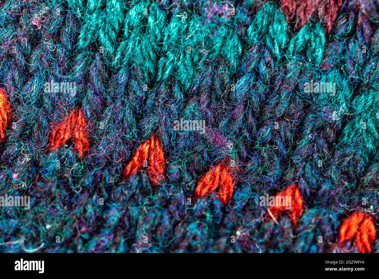 Gewebter Textilhintergrund, warmer und farbenfroher Pullover mit Wollstruktur und Musterhintergrund in Nahaufnahme Stockfoto