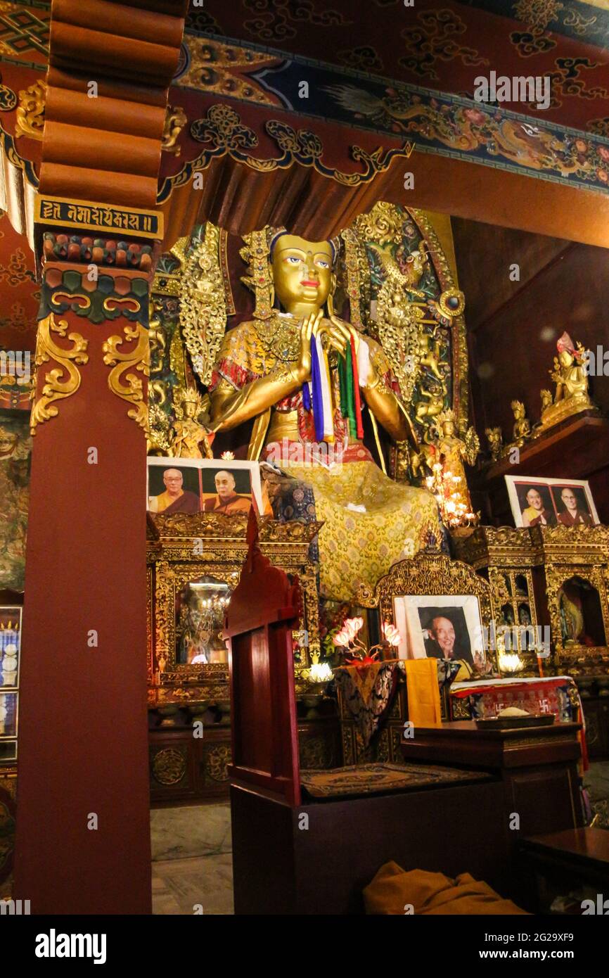 Blick auf das Innere einer Gompa in der Nähe der großen Stupa. Es gibt eine große vergoldete Buddha-Statue und reich verzierte Wände und Säulen. Stockfoto