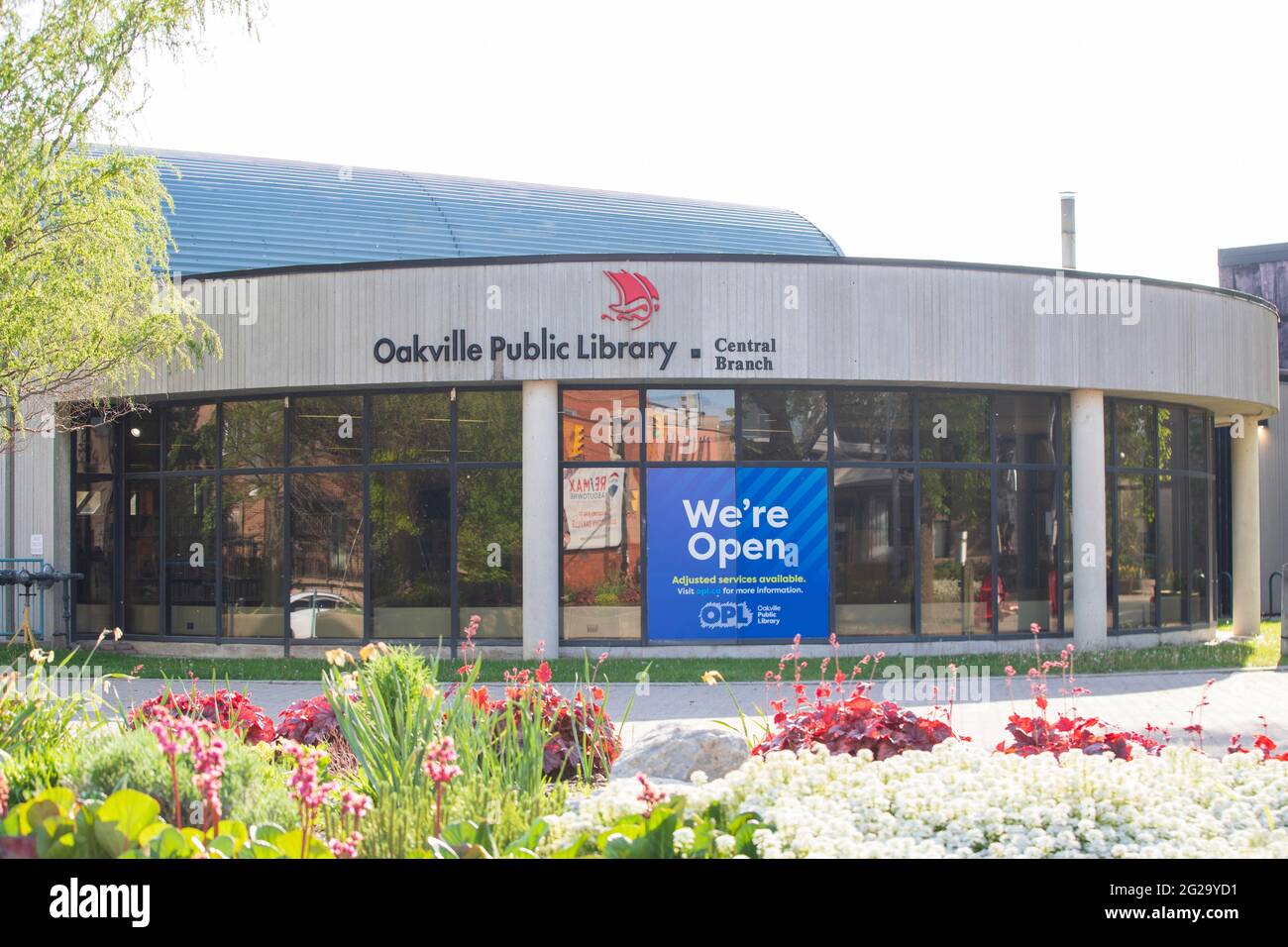 Zentrale Zweigstelle der Oakville Public Library. Ein Schild sagt, dass wir geöffnet sind, öffentliche Plätze werden nach der Pandemie allmählich wieder geöffnet. Stockfoto