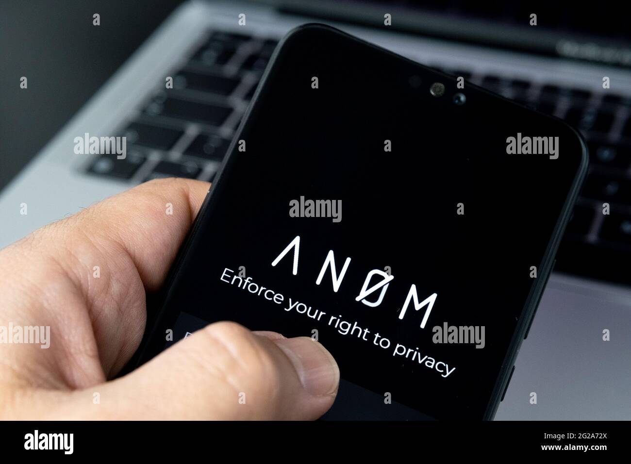 ANOM App-Logo auf dem Smartphone und Laptop auf unscharfem Hintergrund. Verschlüsselte Messaging-App, die in globalen Verbrechernetzwerken verwendet wird. Konzept. Stafford, Vereinigt Euch Stockfoto