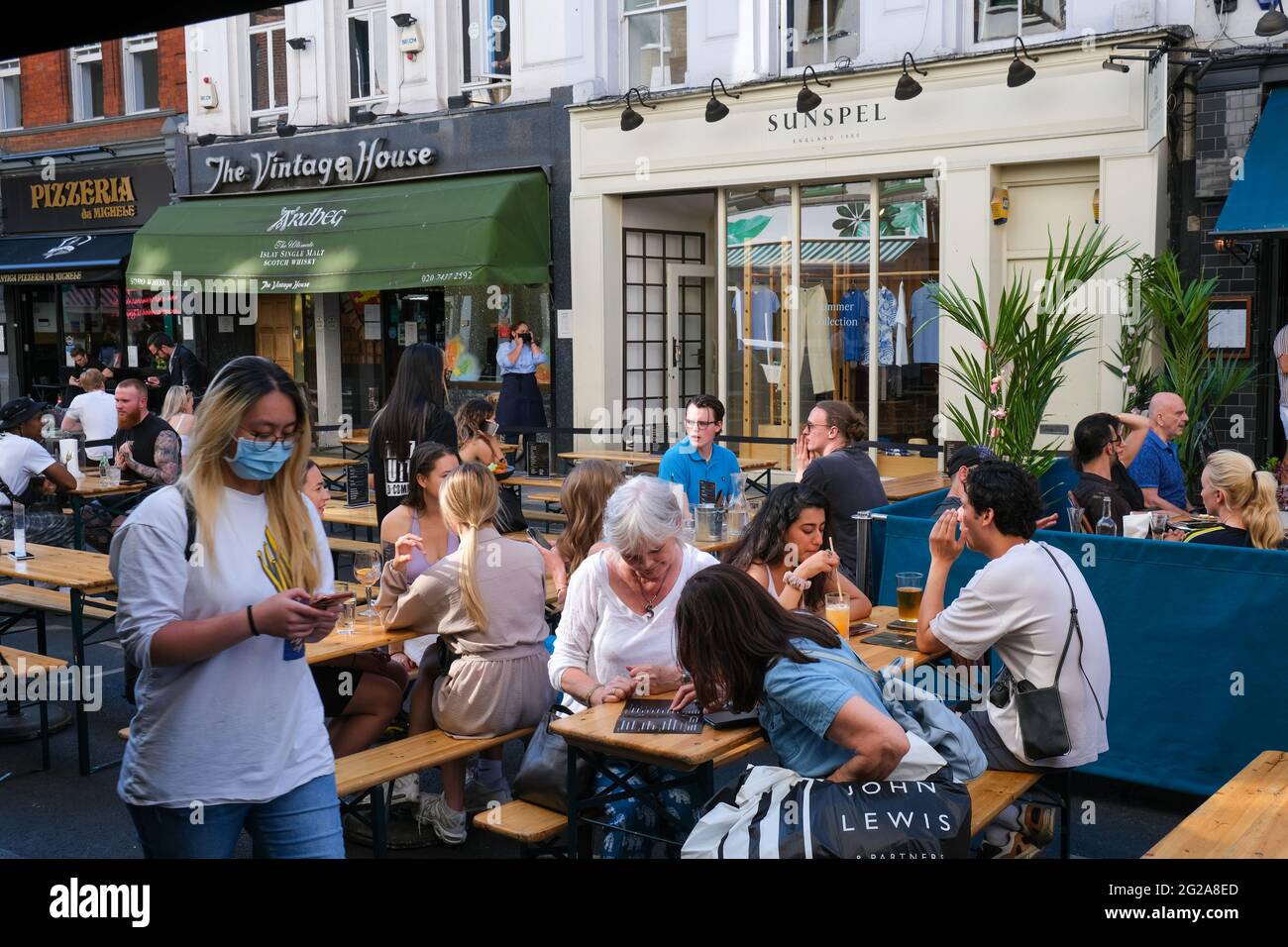 Besucher von West End genießen einen warmen Sommertag nach Aufhebung der Beschränkungen der Pandemie Covid-19, Old Comton Street, London, Großbritannien Stockfoto