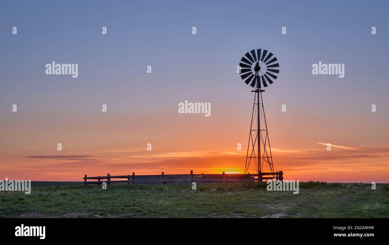 Windmühle mit Wasserpumpe gegen Sonnenaufgang in der Shortgrass-Prärie, Pawnee National Grassland in Colorado Stockfoto