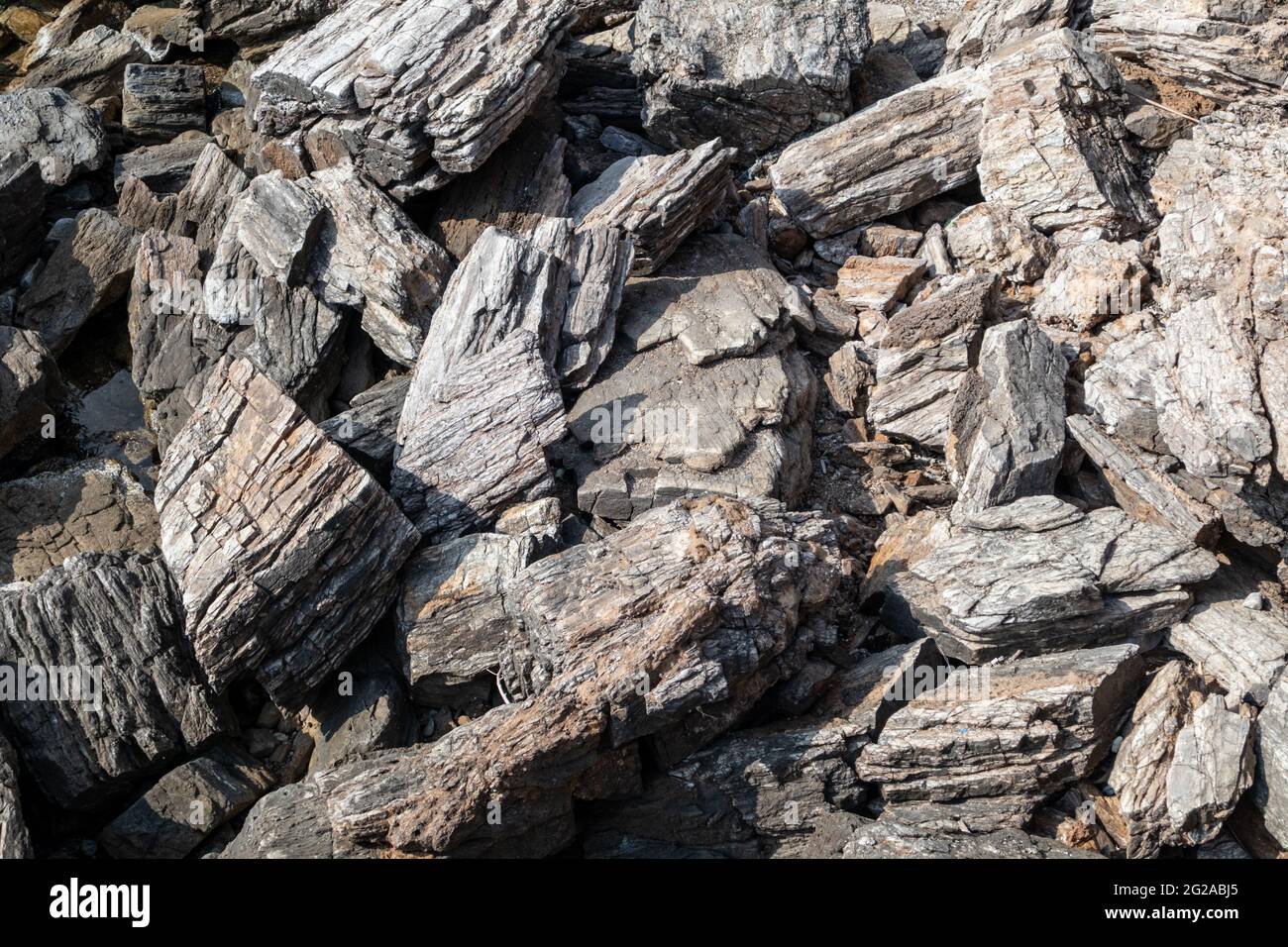 Das Ägäische Meer mit scharfen, großen Felsen und einer Nahaufnahme. Verschiedene felsige Oberfläche im sonnigen Griechenland in der Nähe von Athen Stockfoto