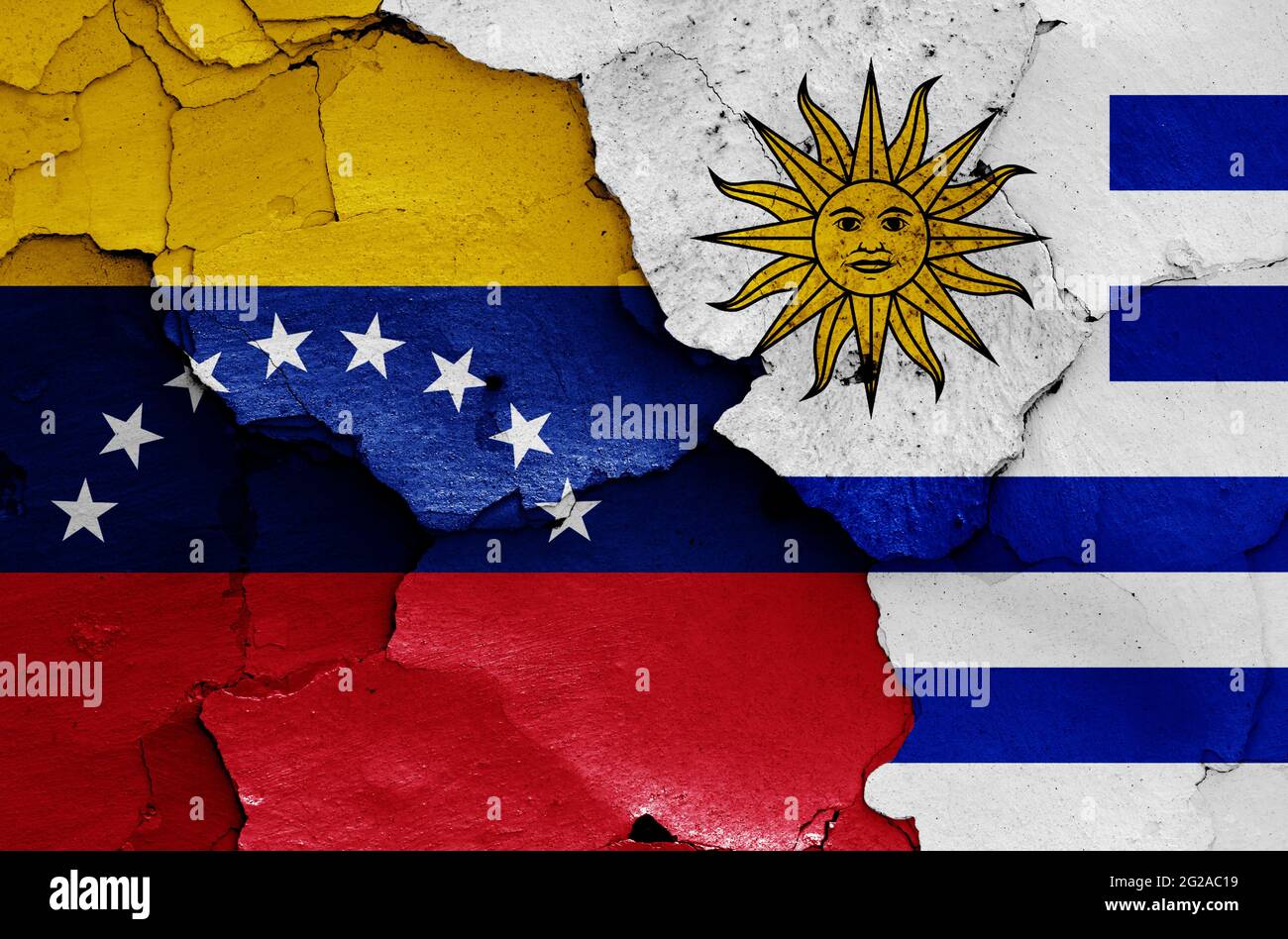 Flaggen von Venezuela und Uruguay auf rissige Wand gemalt Stockfoto