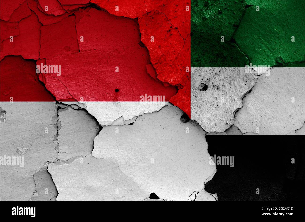 Flaggen von Indonesien und den Vereinigten Arabischen Emiraten auf rissige Wand gemalt Stockfoto