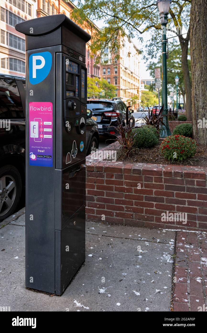 Syracuse, New York - 25. September 2020: Parkscheinautomat identifiziert durch den Buchstaben P mit geparkten Autos im Hintergrund. Stockfoto