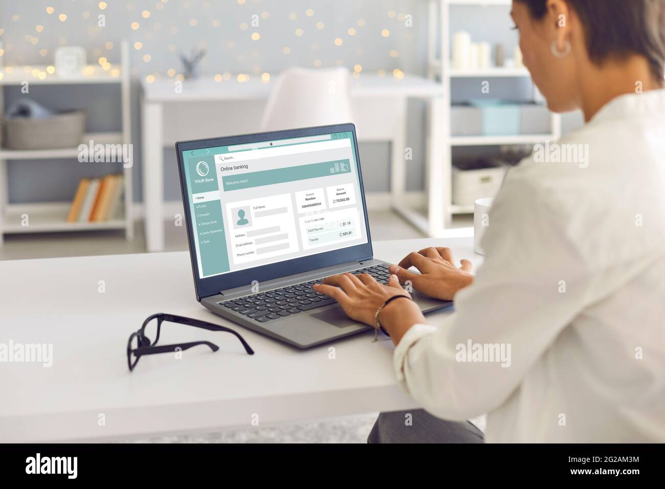 Frau, die ihren Laptop benutzt, ihr Bankkonto verwaltet und online Geld überführt Stockfoto