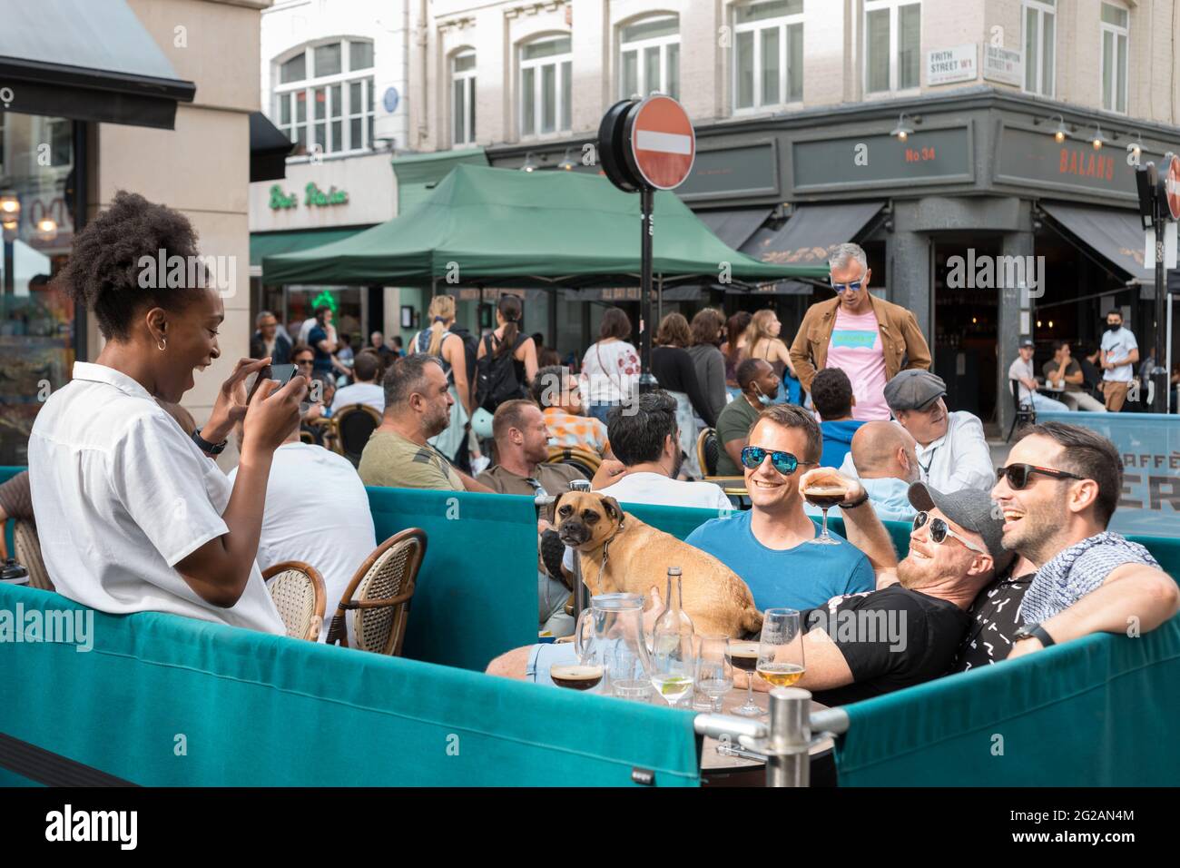 London, Großbritannien. Juni 2021. Eine Kellnerin macht Fotos von Kunden in einem Pub in Soho, London.als die britische Regierung die Beschränkungen für den Restaurantservice in Bezug auf COVID aufhob, überfluteten viele Menschen am Wochenende Restaurants, Bars und Pubs im Zentrum Londons, um einen Drink zu nehmen. Restaurants tun ihr Bestes, um eine Hygiene in ihren Räumlichkeiten zu gewährleisten, und ergreifen immer noch Maßnahmen, um einen sicheren Abstand zwischen den Tischen zu gewährleisten. Die Menschen sind sehr aufgeregt über die Wiedereröffnung in London. Quelle: Belinda Jiao/SOPA Images/ZUMA Wire/Alamy Live News Stockfoto