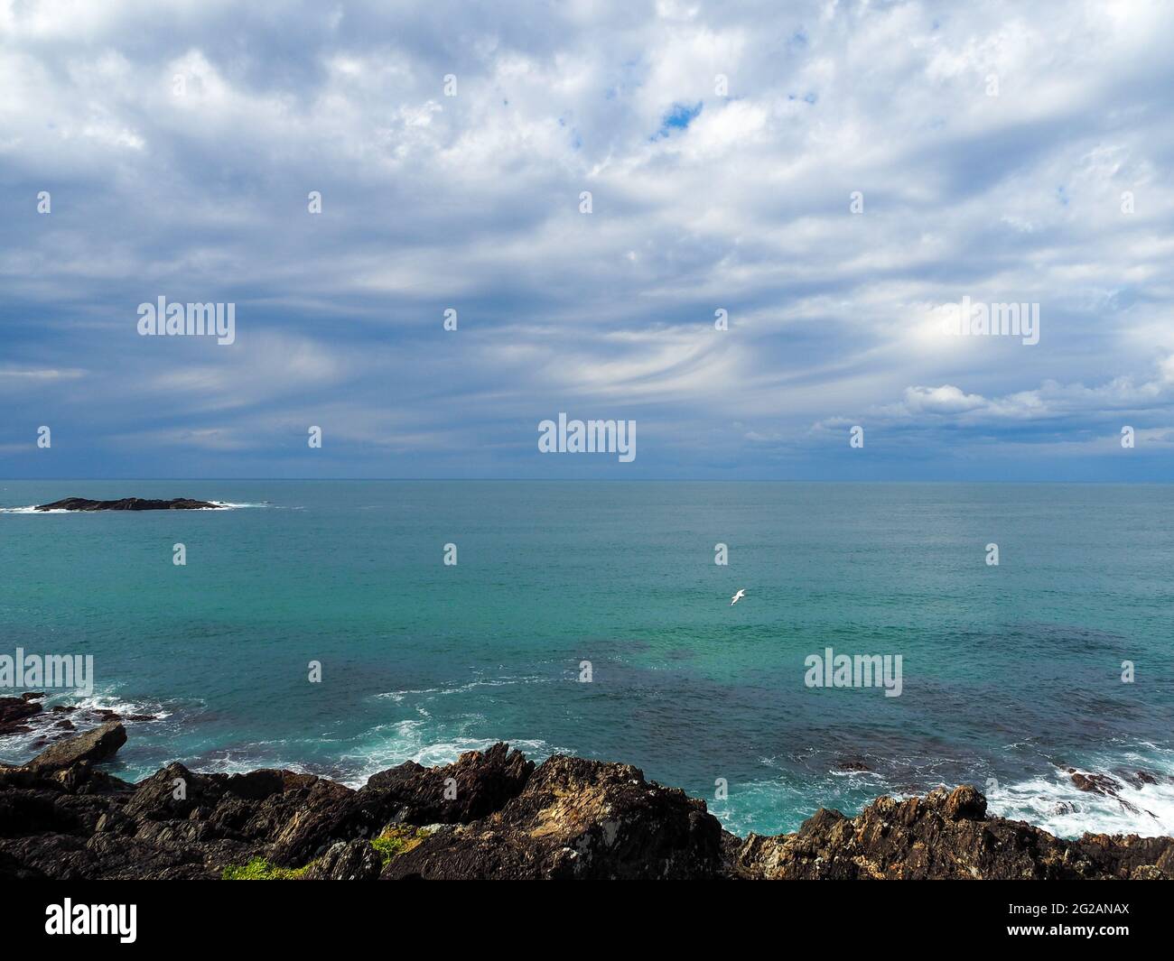 Blau-grünes und türkisfarbenes Meer vor den schwingenden Wolken in dieser atemberaubenden australischen Meereslandschaft, Pazifik bis Horizont, Sawtell, NSW Stockfoto
