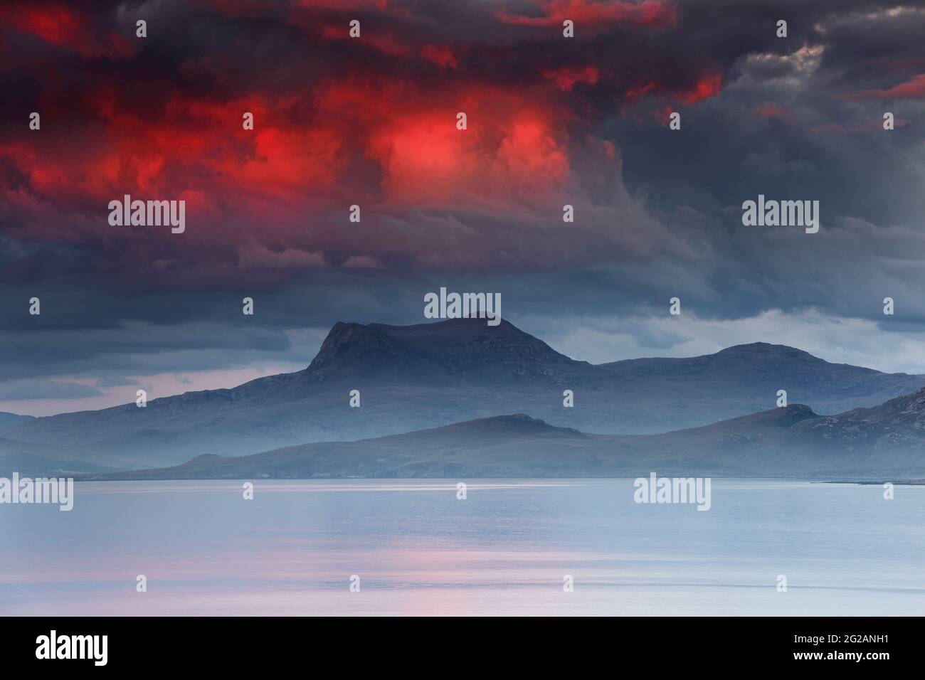 Feuriger Himmel über dem Berg Beinn Ghoblach in der Dämmerung mit Blick auf eine Misty Gruinard Bay von Mellon Udrigle, Wester Ross, Highland, Schottland, Großbritannien Stockfoto