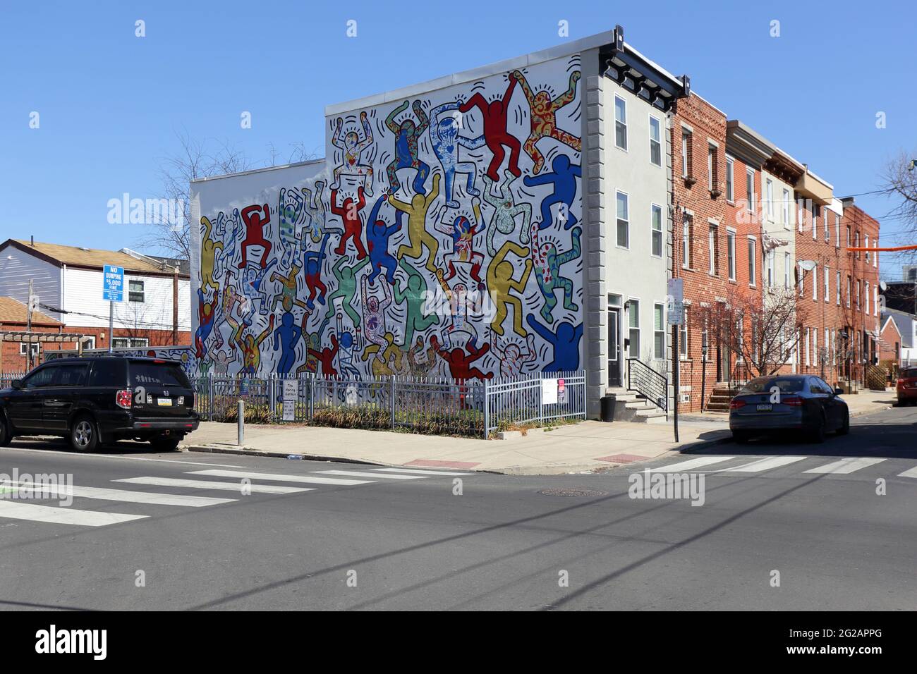 Ein Gemeinschaftsgarten im Point Breeze-Viertel von Philadelphia, PA, mit einem großen öffentlichen Wandgemälde an der Seite eines Gebäudes. Stockfoto