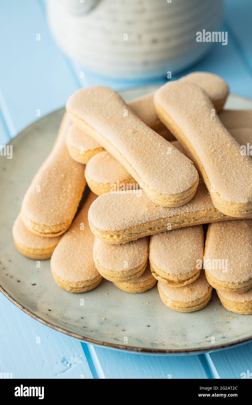 Italienischer Keks savoiardi. Süße Kekse. Biskuit-Kekse tiramisu auf blauem Tisch. Stockfoto