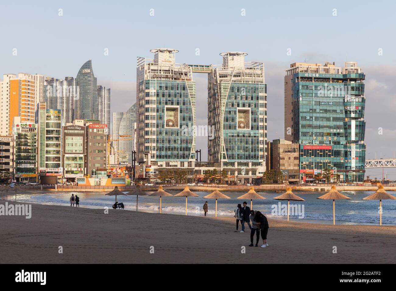 Busan, Südkorea - 16. März 2018: Haeundae-Strandblick, Skyline von Busan mit modernen Hotels an der Küste. Normale Leute laufen am Strand entlang Stockfoto