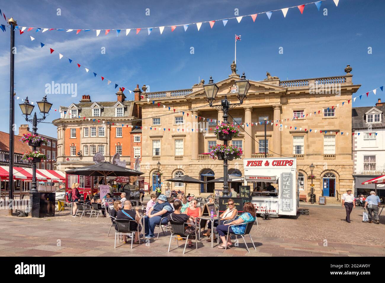 4. Juli 2019: Newark on Trent, Nottinghamshire, Großbritannien - Menschen trinken Kaffee in einem Café auf dem historischen Marktplatz, mit dem Rathaus hinter sich. Stockfoto