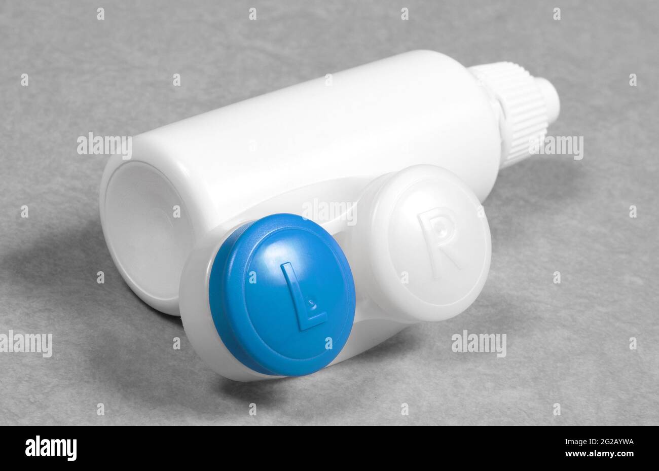 Blauer Kontaktlinsenkoffer und Flasche mit Lösung, isoliert auf grauem Hintergrund Stockfoto