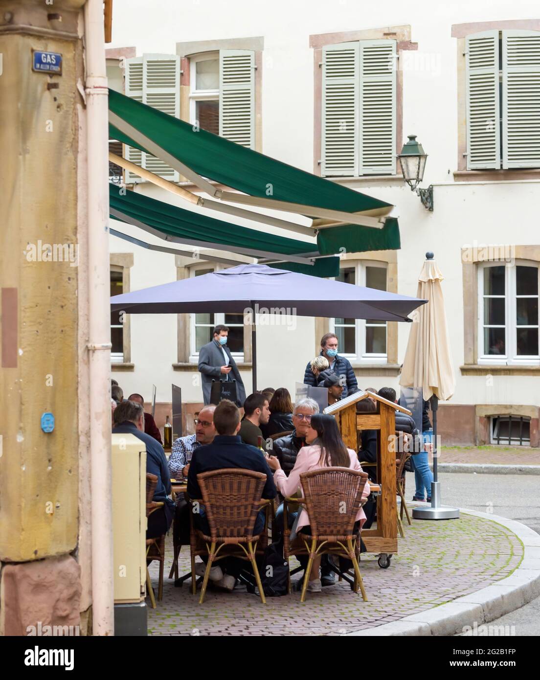 Seitenansicht von jungen Leuten, die auf der Terrasse des französischen Restaurants trinken Stockfoto