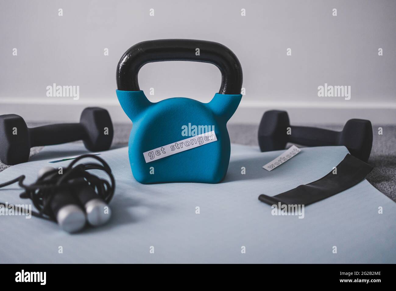 Gym Zeit und Training in Ihrer Freizeit konzeptuelle Bild, Kettlebell mit Hanteln und Überspringen Rop auf Yoga-Matte auf Schlafzimmer Boden mit stärker werden Stockfoto