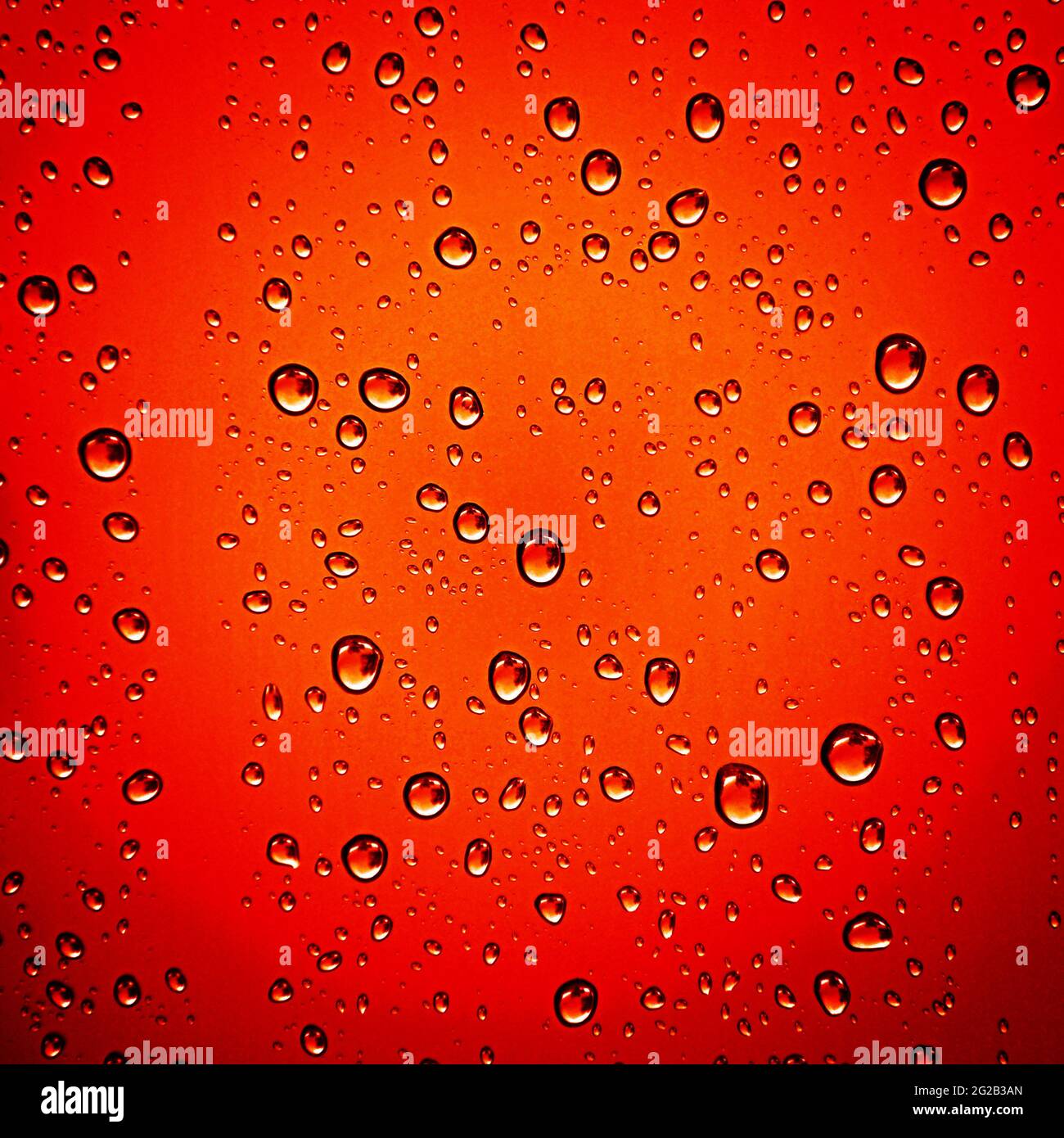 Wassertropfen auf orange-rotem Hintergrund Stockfoto