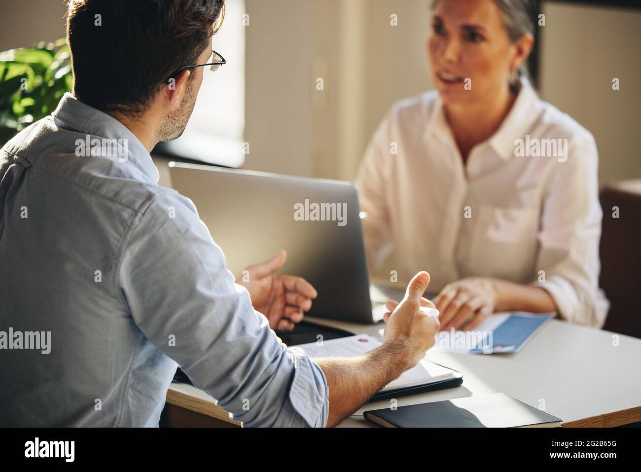 Mann, der für ein Vorstellungsgespräch am Tisch sitzt. Männlicher Kandidat, der einem Arbeitgeber im Amt ein Vorstellungsgespräch gibt. Stockfoto