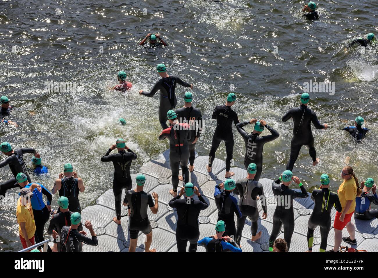 Männliche Triathleten springen beim Schwimmwettbewerb beim AJ Bell London Triathlon 2018, Großbritannien, ins Wasser Stockfoto