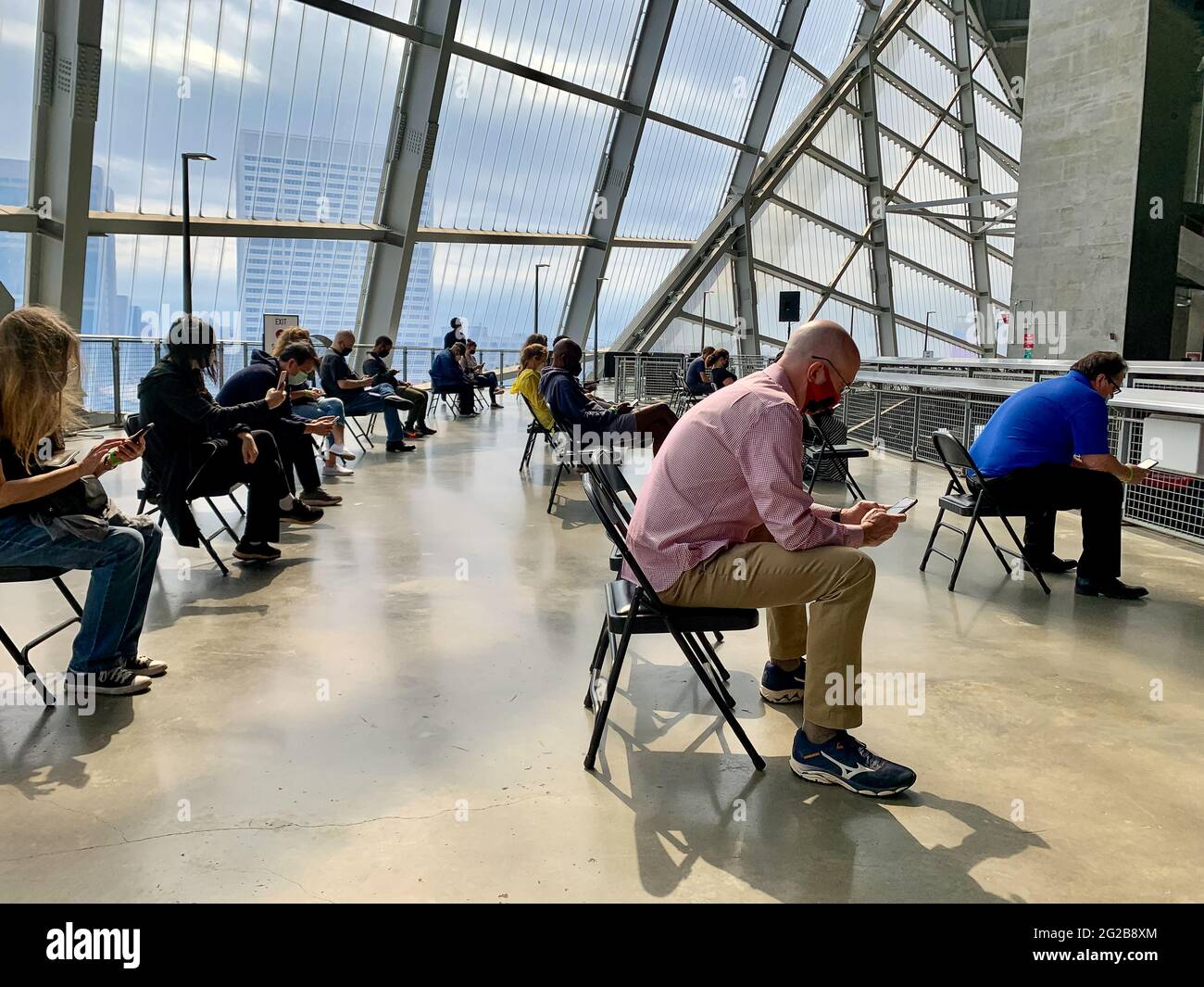 ATLANTA, GEORGIA, USA - 26. März 2021: Menschen im Mercedes-Benz Stadium tragen Masken und sitzen sozial distanziert und warten fünfzehn Minuten Stockfoto