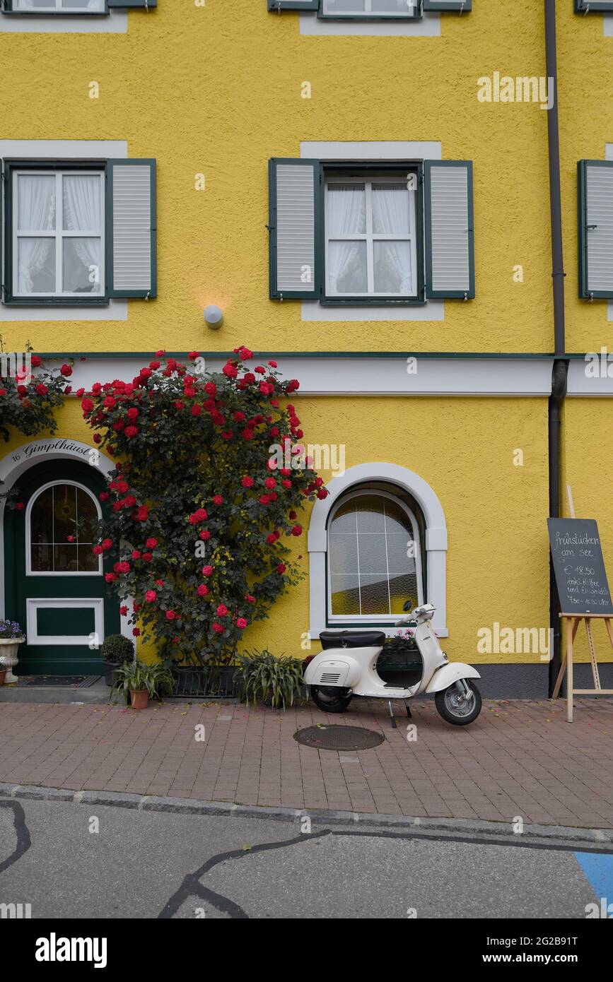 HALLSTAT, ÖSTERREICH - 08. Jan 2021: Typisch österreichisches Alpenhaus mit hellen Blumen auf dem Balkon Stockfoto