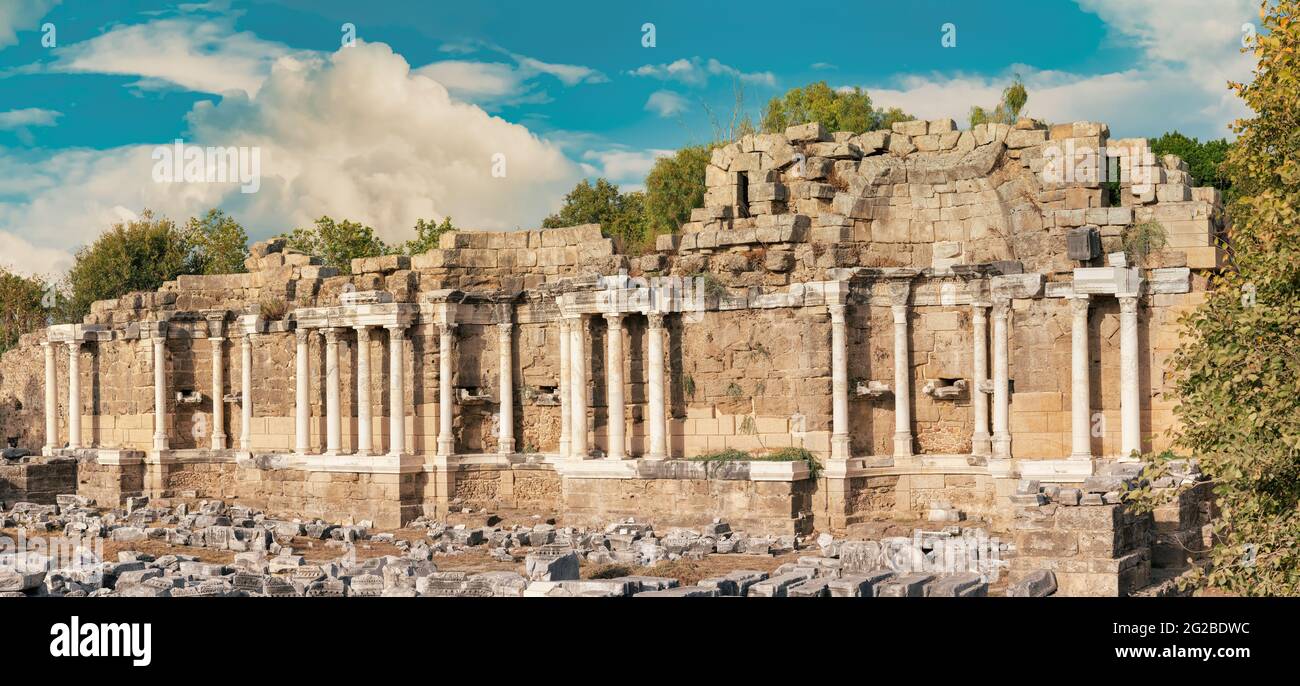 Panoramablick auf die Ruinen der Säulen des Nymphaeum-Brunnens in der alten Seite in Manavgat County während des Sonnenuntergangs. Kulturtourismus Reiseziel. Stockfoto