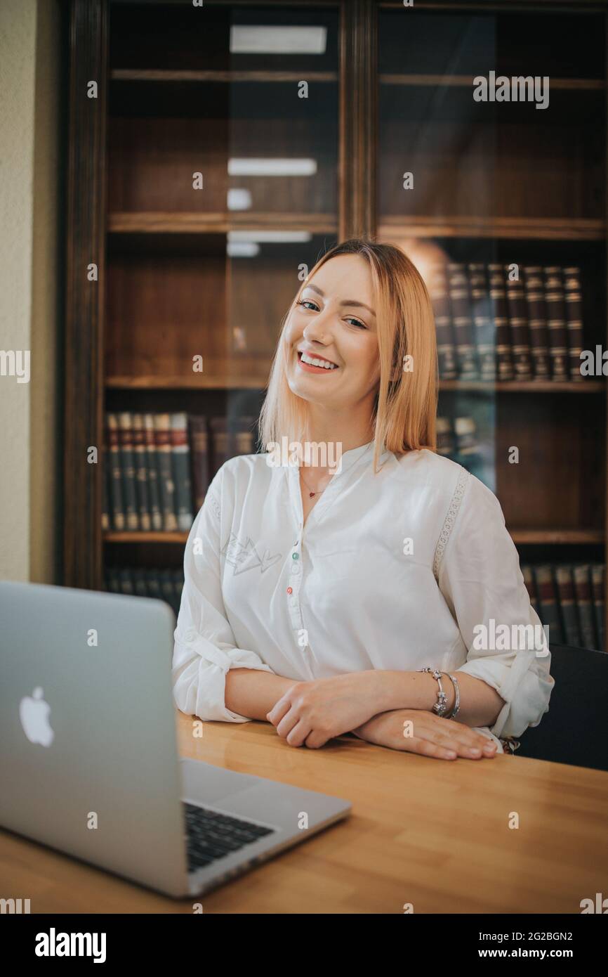 BRCK, BOSNIEN UND HERZEGOWINA - 02. Jun 2021: Aufnahme einer jungen Frau, die formelle Kleidung trägt und im Büro am Laptop arbeitet Stockfoto